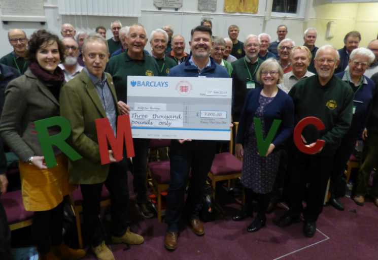 Large group of people holding a large cheque for charity.